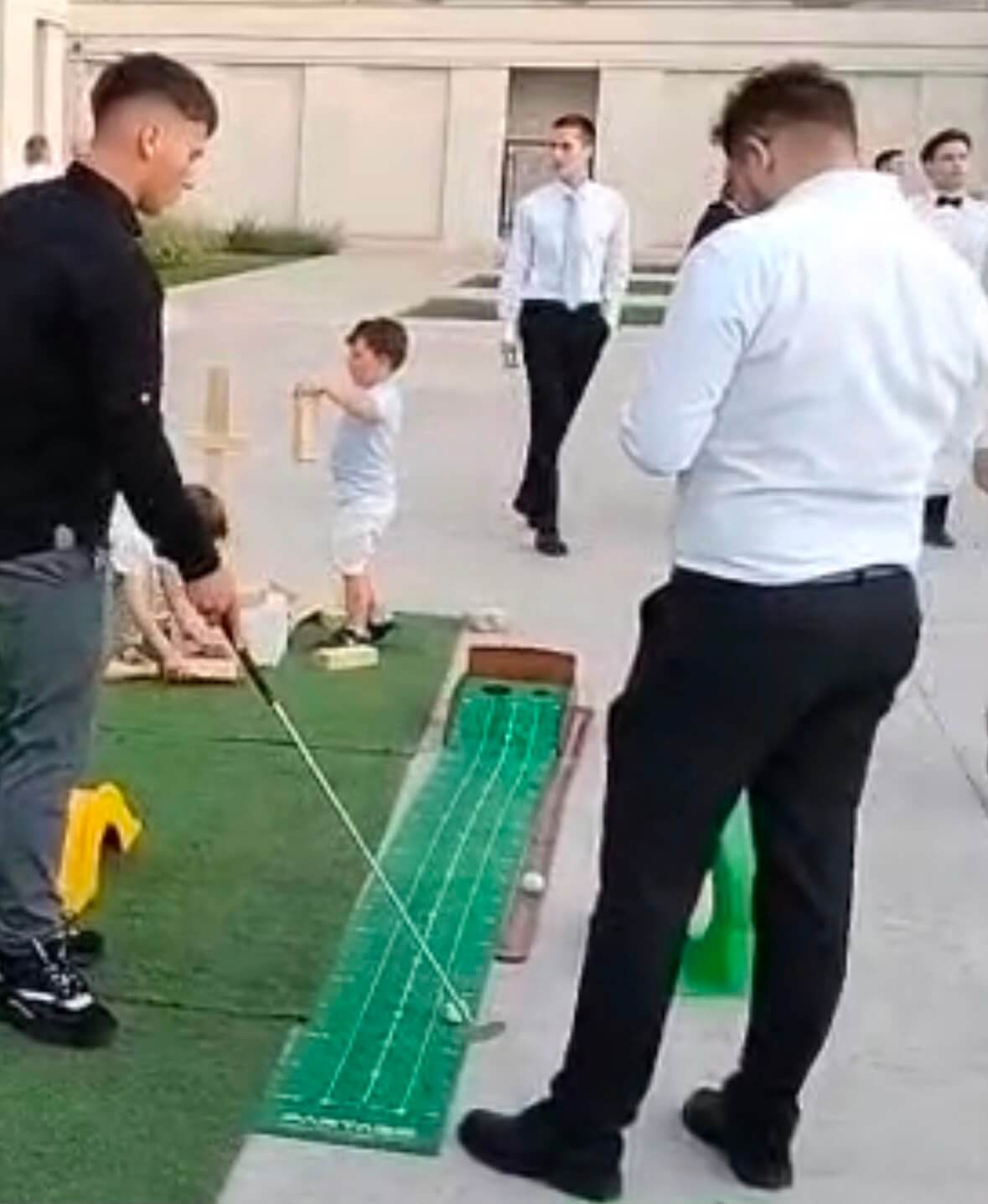Invitați jucând golf pe pista de putting la un eveniment